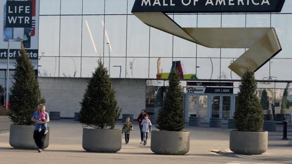 FILE - Shoppers, visitors and employees exit the Mall of America on March 17, 2020 as the mall in Bloomington, Minn. An area near the Mall of America was closed Friday evening April 21, 2023 as authorities were negotiating with a man who is believed to have a gun. (AP Photo/Jim Mone, File)