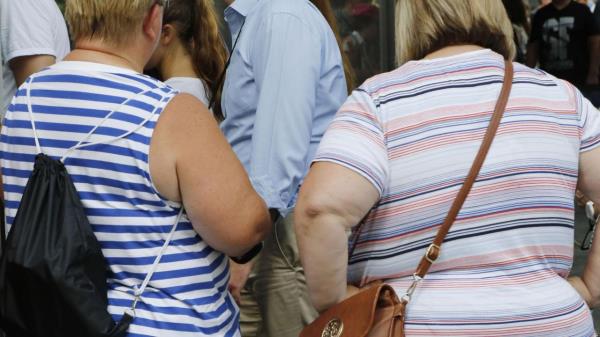 FILE — Two women stand on Aug. 16, 2016, New York. New York City Mayor Eric Adams signed a bill Friday, May 26, 2023, that will prohibit discrimination ba<em></em>sed on body size by adding weight and height to the list of protected categories like race, sex and religion. (AP Photo/Mark Lennihan, File)