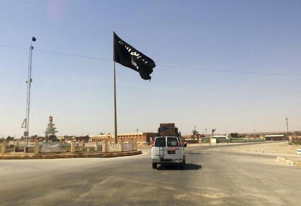 FILE - A vehicle passes by a flag of the Islamic State group in central Rawah, 175 miles (281 kilometers) northwest of Baghdad, Iraq. U.N. investigators are compiling evidence on the development and use of chemical weapons by Islamic State extremists in Iraq after they seized a<em></em>bout a third of the country in 2014, and are advancing work on the militant group’s gender-ba<em></em>sed violence and crimes against children, Sunni and Shiite Muslims, Christians and Yazidis, the head of the investigative team said Wednesday, June 7, 2023. (AP Photo/File)