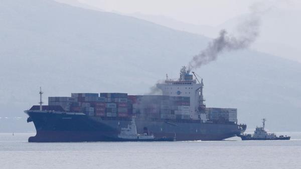 FILE - Cargo ship M/V Bavaria is assisted by tug boats as it prepares to dock at Subic port in Zambales province, northwestern Philippines on Thursday, May 30, 2019. The head of the United Nations called Mo<em></em>nday for maritime nations to agree on a course for the shipping industry to reduce its climate-harming emissions to net zero by the middle of the century at the latest. (AP Photo/Aaron Favila, File)