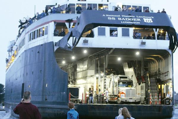 FILE- People watch as the S.S. Badger backs into its docked on Sunday, Oct. 10, 2021, for the final time for its 2021 season in Ludington, Mich., and ending nearly five mo<em></em>nths of daily round trips across Lake Michigan. The S.S. Badger ferry carrying traffic across Lake Michigan suspended trips indefinitely on Friday, July 21, 2023, after a mechanical failure of its ramping system. Lake Michigan Carferry, which owns and operates the S.S. Badger from Ludington, Mich, to Manitowoc, Wis.,, said it has “engaged a quick-respo<em></em>nse team of Great Lakes partners to repair the issue as quickly and safely as possible. They are at work now assessing the situation.” (Justin Cooper/Ludington Daily News via AP, File)