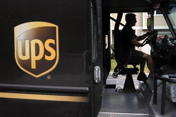 FILE - United Parcel Service driver Hudson de Almeida steers through a neighborhood while delivering packages, Friday, June 30, 2023, in Haverhill, Mass. UPS has reached a co<em></em>ntract agreement with its 340,000-person strong unio<em></em>n Tuesday, July 25, averting a strike that had the potential to disrupt logistics natio<em></em>nwide for businesses and households alike. (AP Photo/Charles Krupa, File)