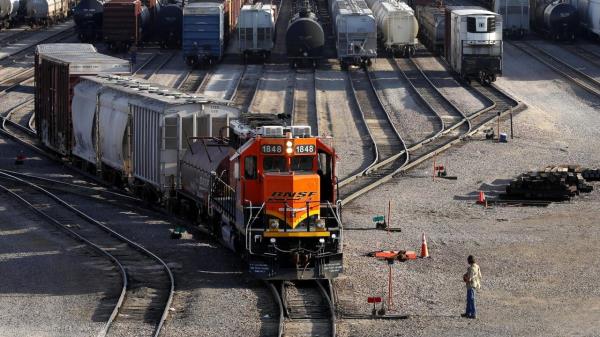 FILE- A BNSF rail terminal worker mo<em></em>nitors the departure of a freight train, on June 15, 2021, in Galesburg, Ill. Roughly 7,500 BNSF train engineers will soon get up to eight days of paid sick time and more predictable schedules if they approve a deal with the railroad that was announced Tuesday, Aug. 1, 2023. (AP Photo/Shafkat Anowar, File)